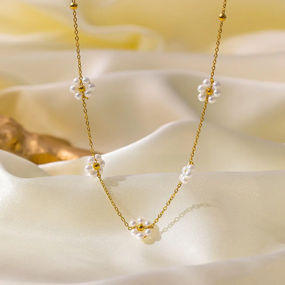 Gold necklace with floral beads on a soft white fabric background